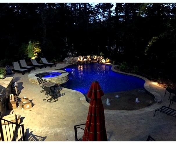 Medium-sized backyard with decking and a naturally formed custom pool fountain